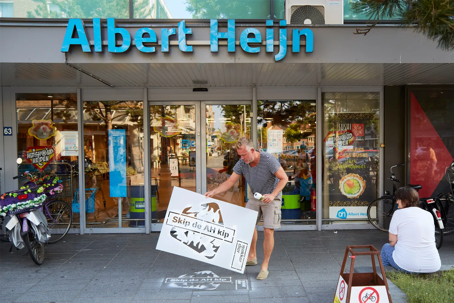 Beeld: krijtgraffiti op de stoep van Albert Heijn met de tekst Skip de AH kip